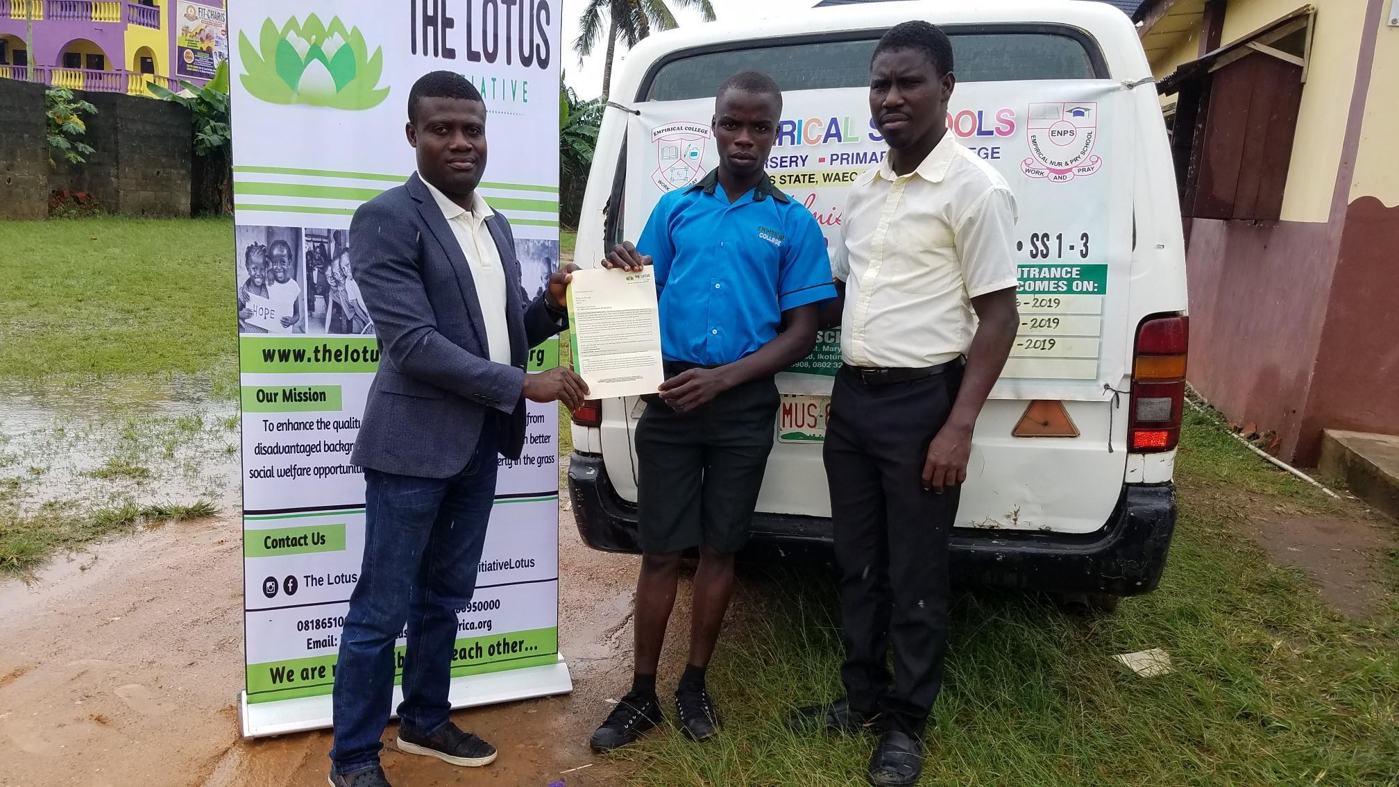 Lotus Initiative Program Manager presenting Scholarship offer letter to Master Tunde Sherrif with a staff of Empirical College.